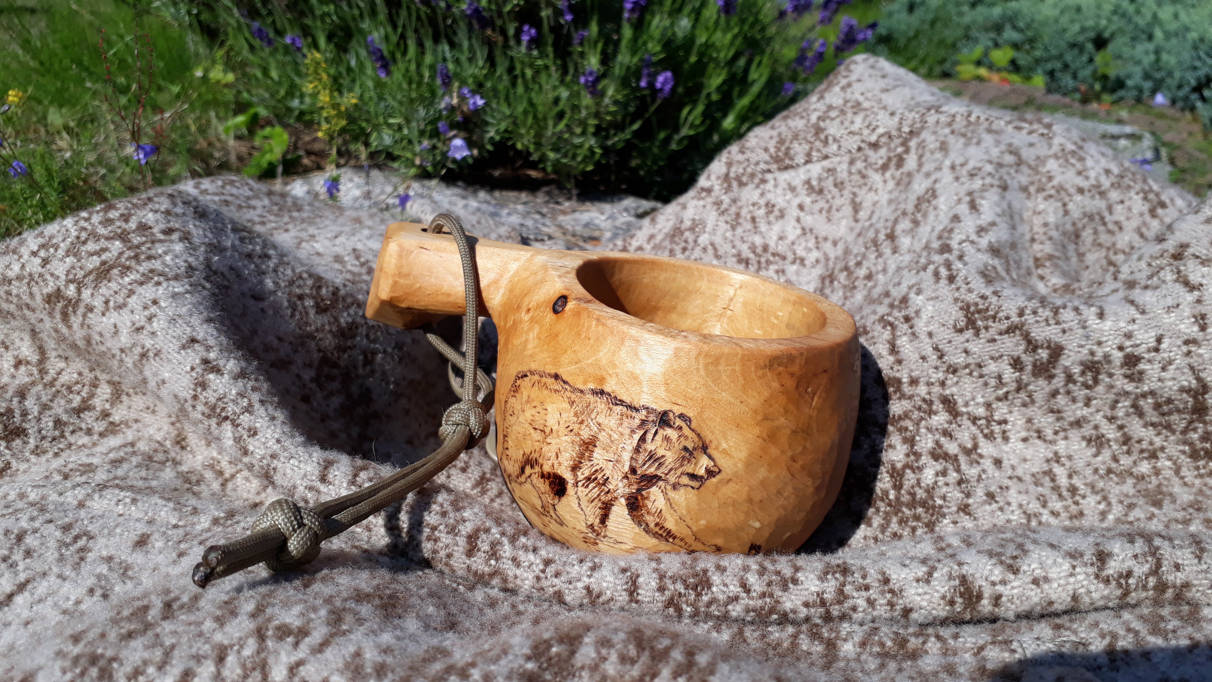 WeatherWool Advisor Eix, from Estonia, carved this Kuksa ... and the bear! The Kuksa is photographed on top of Eix's Al's Anorak in Lynx Pattern