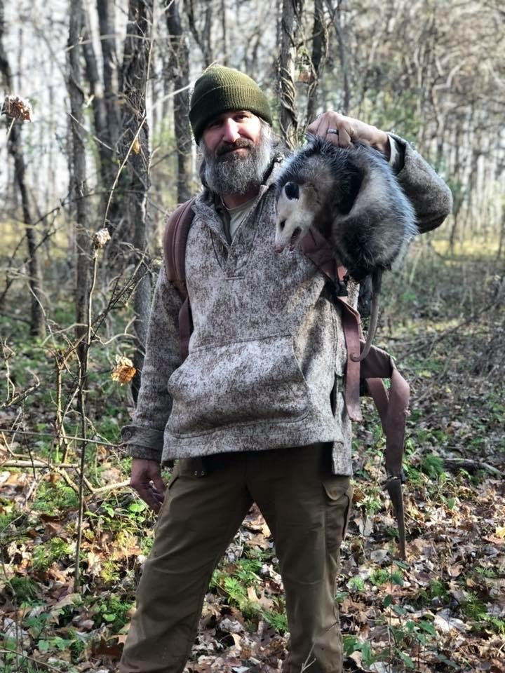 WeatherWool Advisor Josh Enyart in his Lynx Pattern WeatherWool Anorak with a possum playing possum (animal is unhurt)